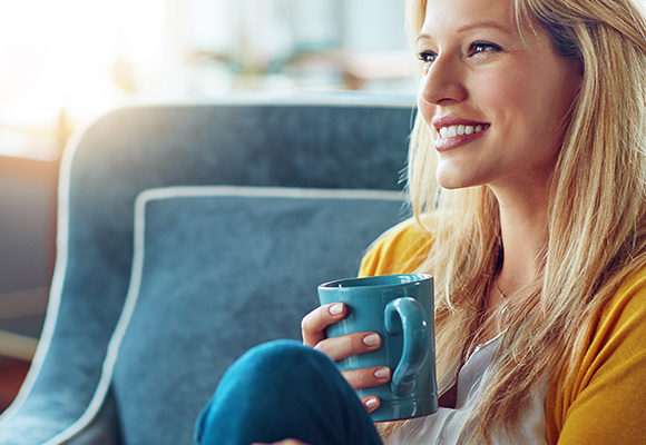 Happy woman drinking coffee to promote household insurance broker Full-time Cover
