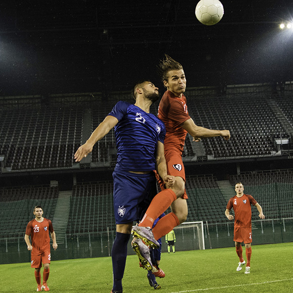 Footballers collide to hit ball on pitch to promote leading football insurance broker Full-time Cover
