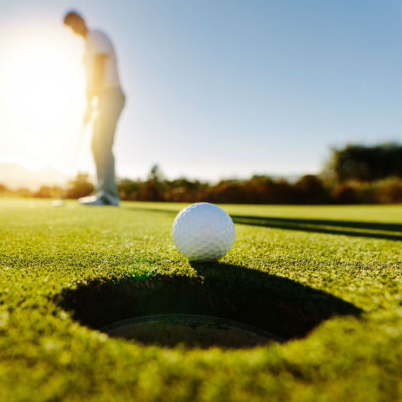 Golf ball teetering on hole to promote leading golf insurance brokers Full Time Cover