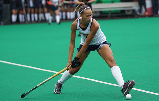Woman hitting puck with hockey stick to promote leading hockey insurance broker Full-time Cover