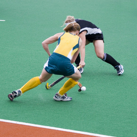 Young hockey players guiding the ball to promote leading hockey insurance brokers Full Time Cover