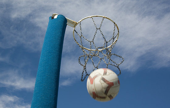 Netball passing through goal to promote leading netball insurance broker Full-time Cover