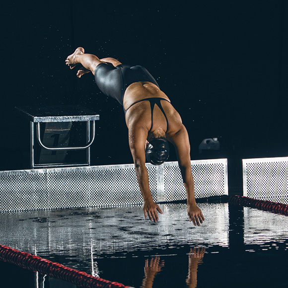 Professional swimmer diving into pool to promote leading swimming insurance broker Full-time Cover