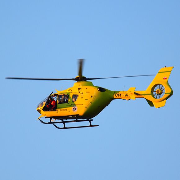 Emergency helicopter flying through blue sky to demonstrate Full Time Cover Insurance Broker's Topup Travel Insurance
