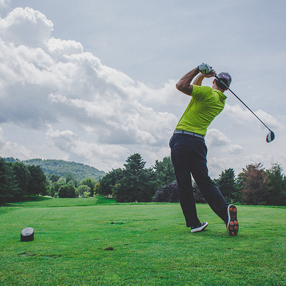 Man swinging at golf ball on green to promote Full Time Cover's Amateur Golf Insurance